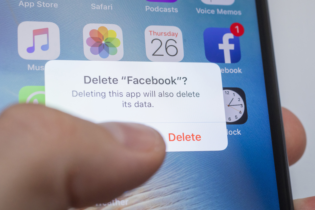 un dedo de una persona borrando contenido de Facebook