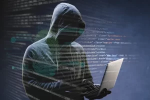 Hacker usando laptop con código digital, relacionado con agencia de reputación online en México.